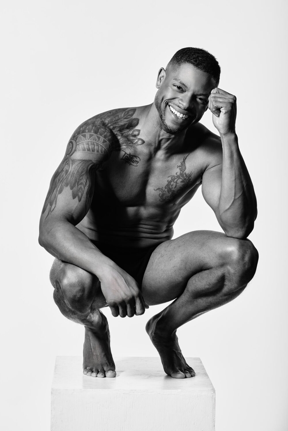 Black and white image of a muscular male model smiling