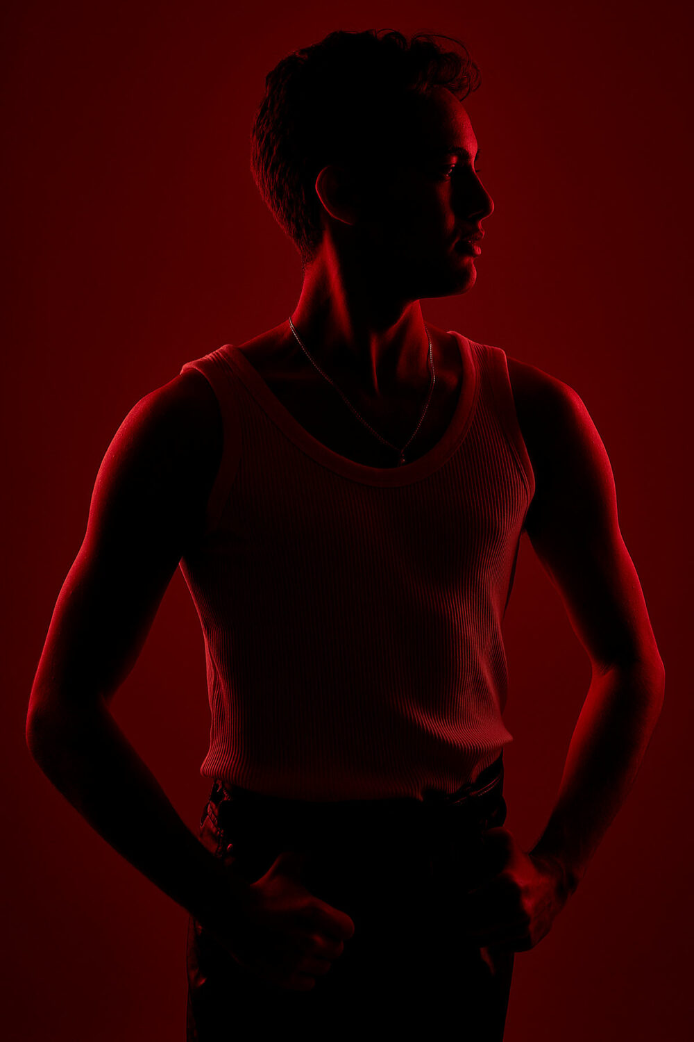 A male model standing with a red back light by Emily Teague